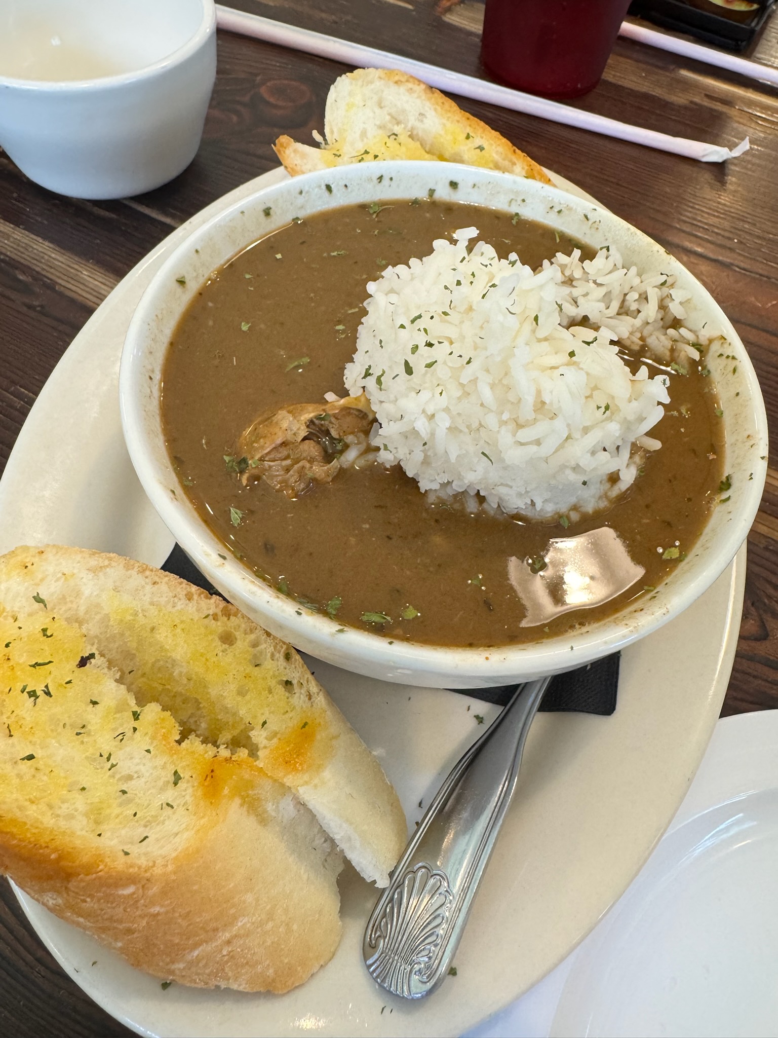 Prepped ingredients for Cajun jambalaya laid out on a kitchen counter, including  sausage, chicken, chopped vegetables, and herbs.